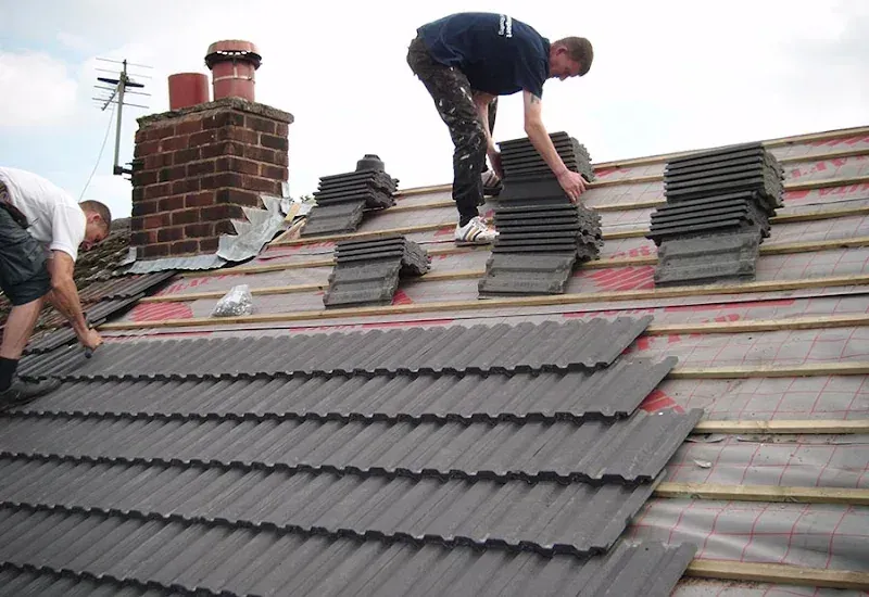 Cotsworld roofers installing new grey concrete tiles on a Birmingham property